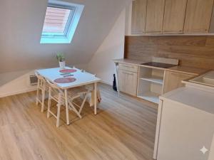 a small kitchen with a white table and a counter at Le 3eme Mistral in Molsheim