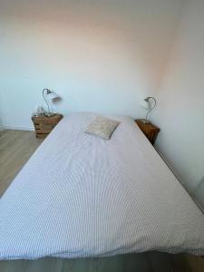 a white bed with two lamps in a bedroom at Le 3eme Mistral in Molsheim