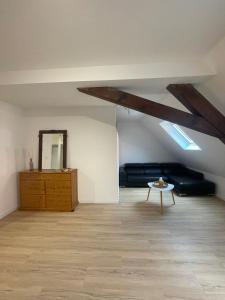an attic room with a couch and a table at Le 3eme Mistral in Molsheim