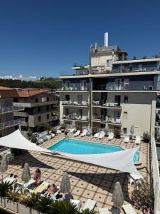 a hotel with a swimming pool in front of a building at Hotel Costa Verde in Pineto