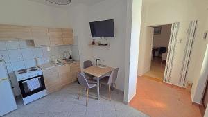 a small kitchen with a table and a stove at Apartment Murva in Primošten
