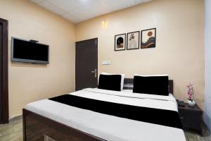 ein Schlafzimmer mit einem großen Bett und einem Flachbildfernseher in der Unterkunft Collection O by OYO Burlton Park Jalandhar Formerly Hotel R1 Inn in Jalandhar