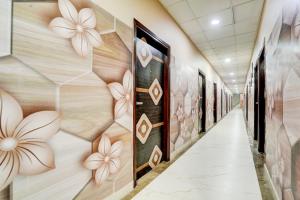 ein Flur mit Gemälden an den Wänden in einem Gebäude in der Unterkunft Collection O by OYO Burlton Park Jalandhar Formerly Hotel R1 Inn in Jalandhar
