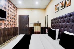 ein Schlafzimmer mit einem großen Bett und einem Fernseher in der Unterkunft Collection O by OYO Burlton Park Jalandhar Formerly Hotel R1 Inn in Jalandhar