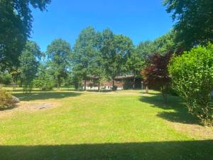 a large grass field with trees and a building at Lo chalet sul lago in Ispra