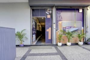 a store front with potted plants in front of a door at Super Hotel O by OYO Silver Arc Mall Ludhiana Formerly White Solitaire 1 in Ludhiana