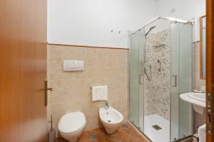 a bathroom with a toilet and a glass shower at Villevieille in Piano di Sorrento +24 photos