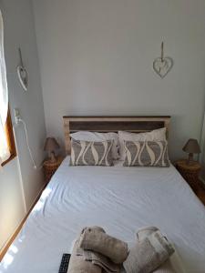 a bedroom with a bed with white sheets and pillows at SOFIA'S HOUSE No 2 in LESVOS in Apidias Lakos