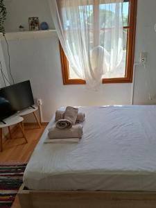 a bedroom with a bed with towels and a window at SOFIA'S HOUSE No 2 in LESVOS in Apidias Lakos