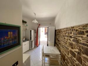 a kitchen with a table and a stone wall at ZIO DOMENICO Al Vicolo in Castellabate