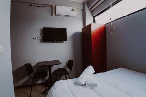 a bedroom with a bed and a table and a tv at HoTELBLU in Santiago +31 photos