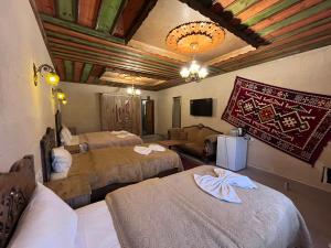 a hotel room with three beds and a tv at Falcon Cave Suites in Göreme +86 photos