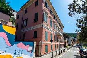 a red building with a mural on the side of a street at Bright Sea View Home, Steps from the Beach in Lavagna