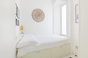 a white bedroom with a bed and a window at Bright Sea View Home, Steps from the Beach in Lavagna