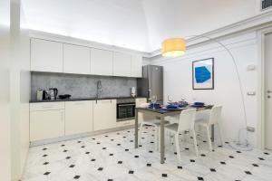 a kitchen with a table and some white cabinets at Bright Sea View Home, Steps from the Beach in Lavagna
