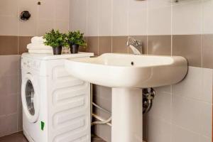 a bathroom with a sink and a washing machine at Design Villa with parking Navigli Milan sleeps5 in Milan +16 photos