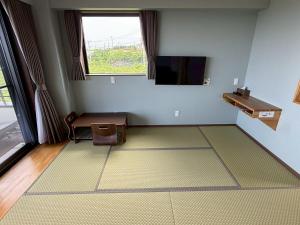 a room with a tv and a table and a chair at Villa resort -悠- in Miyakojima