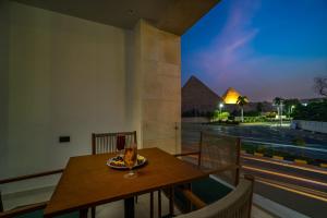 a table and chairs on a balcony with a view of the pyramids at Koun Pyramids Hotel in Cairo