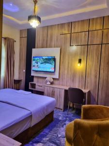a hotel room with a bed and a tv at Sennet Luxury Hotel in Uyo