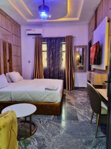 a hotel room with a bed and a table at Sennet Luxury Hotel in Uyo
