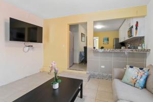 a living room with a couch and a table at Villa Jardin - Infinity Pool and Backyard Oasis in Luquillo