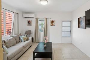 a living room with a couch and a table at Villa Jardin - Infinity Pool and Backyard Oasis in Luquillo