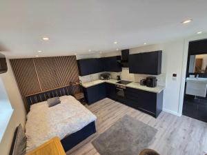 a small bedroom with a bed and a kitchen at The Out House in Hemel Hempstead