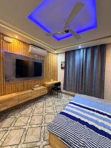 a bedroom with a flat screen tv and a bed at RAWADE Guesthouse in Cotonou +4 photos