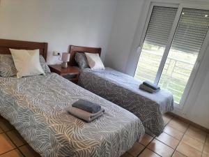 a bedroom with two beds and a window at Golf Paradise in Sant Jordi +4 photos