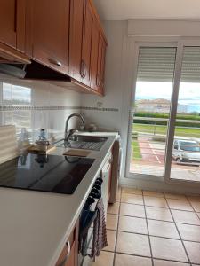 a kitchen with a sink and a stove and a window at Golf Paradise in Sant Jordi
