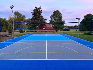 a tennis court with a net on it at Set on peaceful 5 acres, 5 min from town, Private Building, Level 2 EV Charger in Bloomington