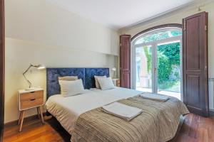 a bedroom with a large bed and a window at Bela Vista in Azambuja