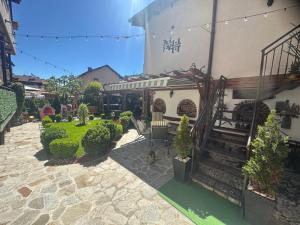 a courtyard with a house with a staircase and plants at NIKI HOUSE in Bansko +62 photos