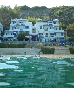 eine Gruppe von Gebäuden vor einem Wasserkörper in der Unterkunft Chios Xenia Studios & Apartments in Paralia Agias Foteinis