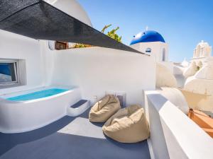 a bathroom with a tub on the side of a building at Three Domes Oia - an Iconic Collection in Oia +101 photos