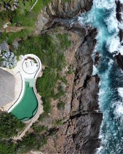 an aerial view of a building on a cliff next to the ocean at Casa Papelillo on Costa Careyes in Chamela