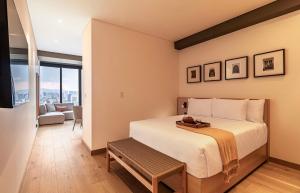 a bedroom with a bed with a bench in it at University Tower by Kukun Apartments in Mexico City +33 photos