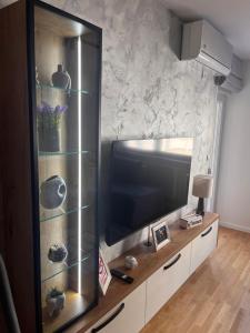 a large entertainment center with a large flat screen tv at Apartman A&V in Vranješ