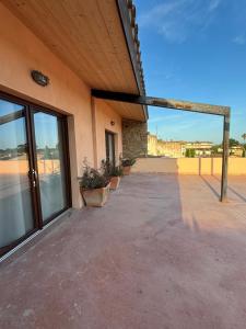 an empty patio of a building with large glass doors at Ca La Botera in Verges
