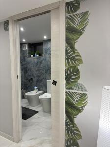 a bathroom with a wall with a mural of leaves at La 75 Stella Home Catania in Catania +19 photos