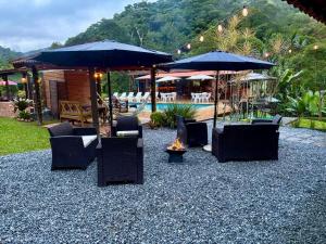 a group of chairs and umbrellas on a gravel patio at Estação Serramar in Lumiar