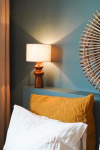 a bedroom with a bed with a lamp and a mirror at Chambre confortable Piscine Maison EtxeCosy in Bidart