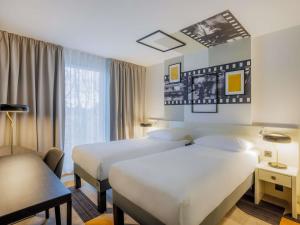 a hotel room with two beds and a window at ibis Styles Tallinn in Tallinn +101 photos