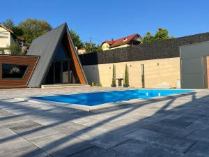 a house with a swimming pool in front of a building at A-Frame Villa - Kovačević Hills in Velika Kladuša