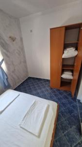 a bedroom with a bed and a wooden cabinet at Apartmani MULIC Sutomore in Sutomore