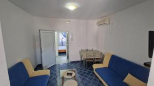a living room with a blue couch and a table at Apartmani MULIC Sutomore in Sutomore