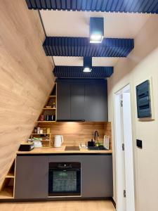 a kitchen with black cabinets and blue ceilings at A-Frame Villa - Kovačević Hills in Velika Kladuša