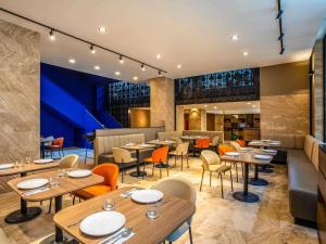 a restaurant with tables and chairs and a bar at Novotel México City Centro Histórico in Mexico City