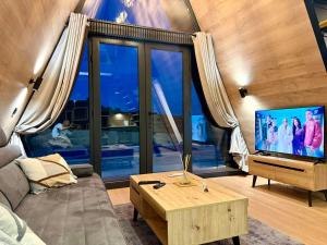 a living room with a couch and a television at A-Frame Villa - Kovačević Hills in Velika Kladuša