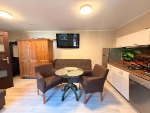a small kitchen with a table and two chairs and a counter at Zefir Domek nr 5 in Dąbki